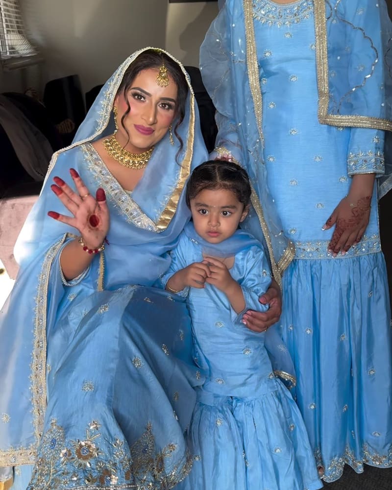Two women and a little girl in matching powder blue farshi suits